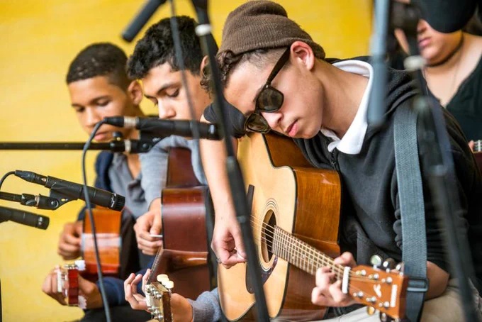 a group of young people playing acoustic guitars
