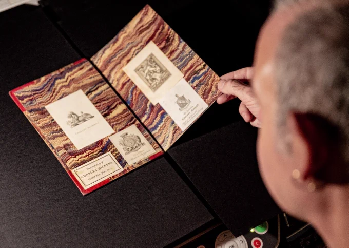 A man handling one of Charles Dickens's reading copies, produced around 1861.