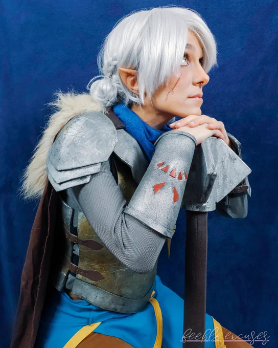 Photo of me dressed as Pike from Critical role. I'm wearing a white wig styled in low buns, short pointed ears, and a full set of foam armour made to look like metal. My chin is resting on a mace.