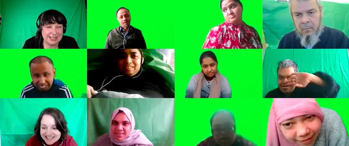 Twelve adults on a Zoom meeting all with a green screen background. Some are smiling. 