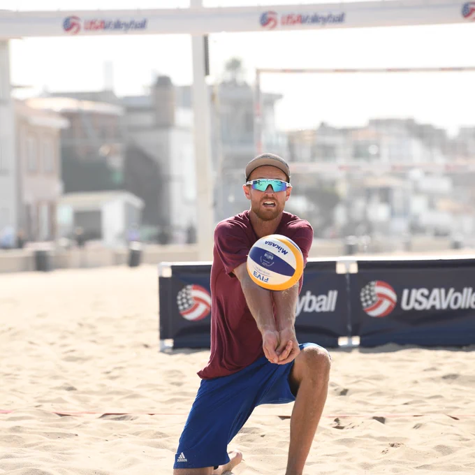 Men's beach volleyball player passes the ball