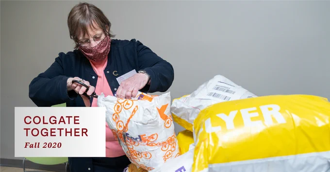 Dr. Miller opens packages of PPE donated by members of the Colgate community. 