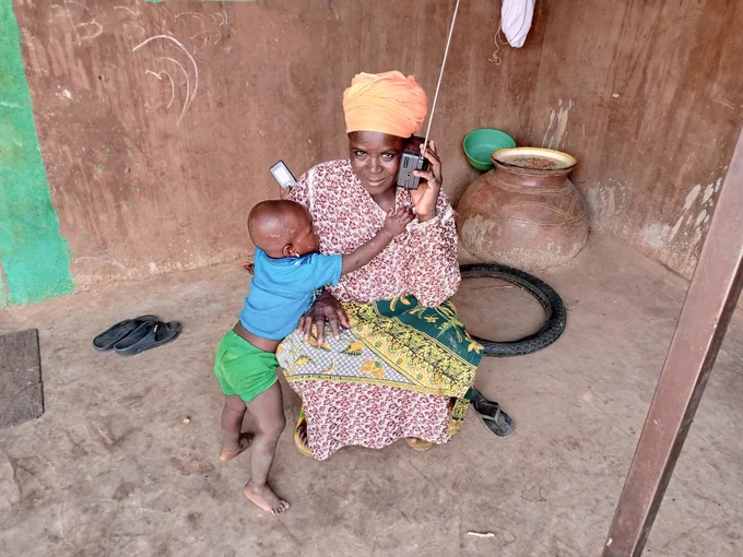 Mariam is a shea butter producer from Jawani, Ghana, and is listening to the radio with her child, Feb 2021.