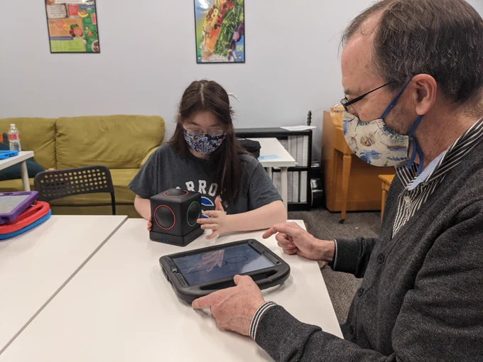 Young girl playing the Skoog with an adult male assistant. 