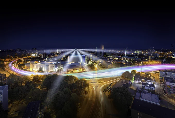A night landscape of Coventry with colourful lights moving along the ring road.