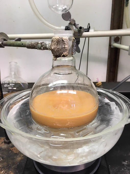The same 1000 mL round bottom, now the solution inside has turned entirely bright orange.
