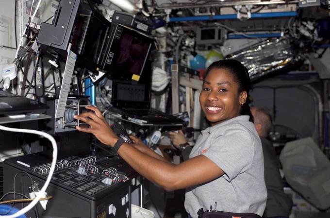 Astronaut Stephanie Wilson smiles as she uses the control for the space station's robotic arm.
