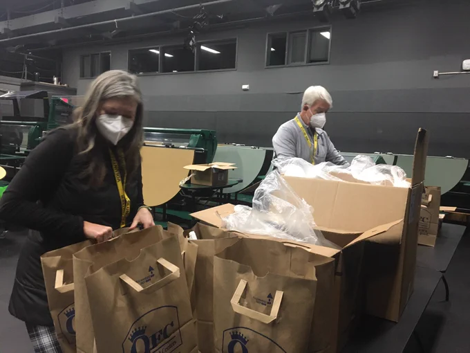 Volunteers filling bags with masks and hand sanitizer