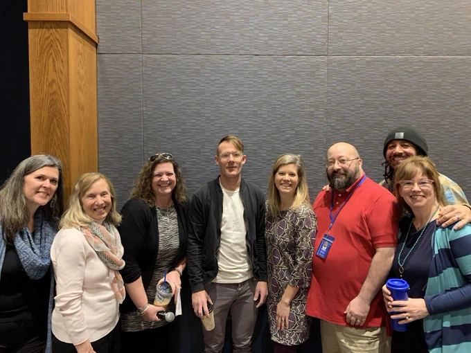 8  adult educators standing together smiling. Left to right- 3 female educators. Fourth from the left is Jonathan Mooney, author of Normal Sucks. Another female, two males and another female end the group.