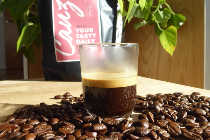 Espresso shot surrounded by coffee beans. Photo by Coffeediff.co.uk