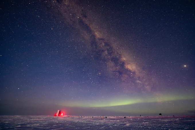 An image of the southern hemisphere sky at night over the Ice Cube Neutrino Observatory, who owns the image copyright. 