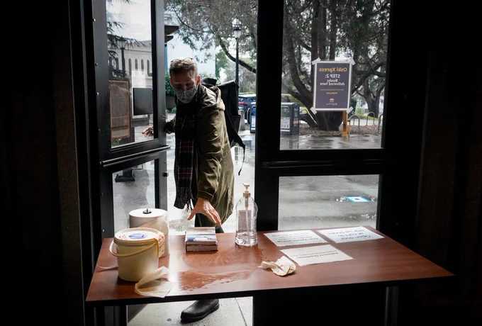 A patron picks up books made available through the UC Berkeley Library’s Oski Xpress contactless pickup service.
