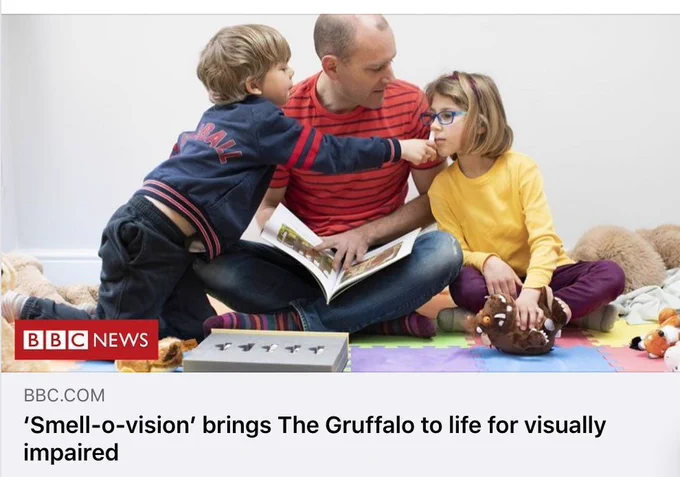 Image shows BBC News page with a man reading The Gruffalo and a young boy holding something to a young girls nose to smell