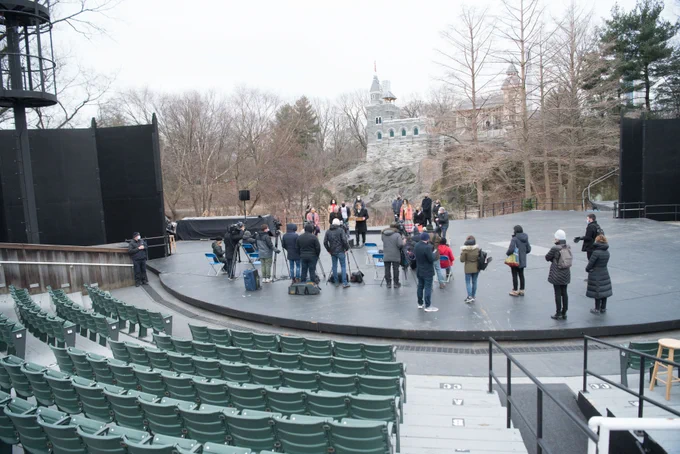 A photo of people standing on an outdoor stage.