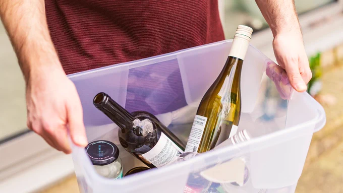 Hands holding a box of recyclable items