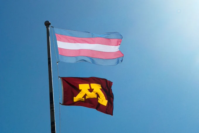 The Trans Pride Flag and the University of Minnesota flag.