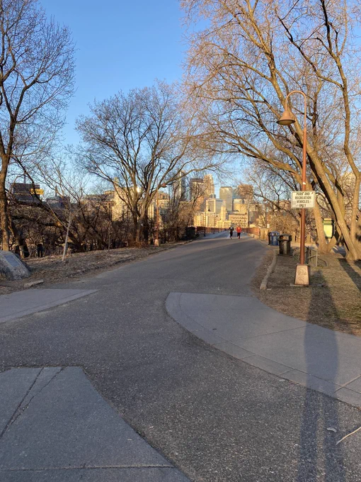 Stone Arch Bridge approach from east side in morning light. A light pole bears a small white sign stating, “Park and Recreation Vehicles Only”