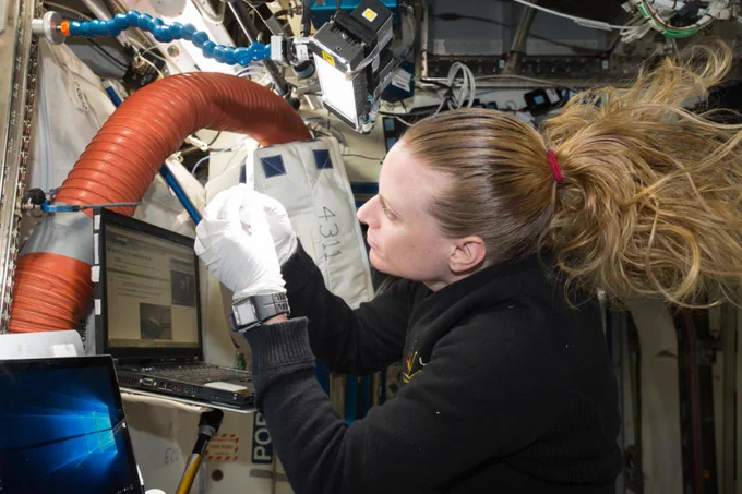 Aboard the International Space Station, NASA astronaut Kate Rubins checks a sample for air bubbles prior to loading it in the biomolecule sequencer.
