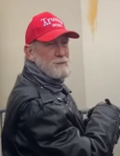 Capitol rioter 290 wearing a red Trump hat and a black leather jacket.
