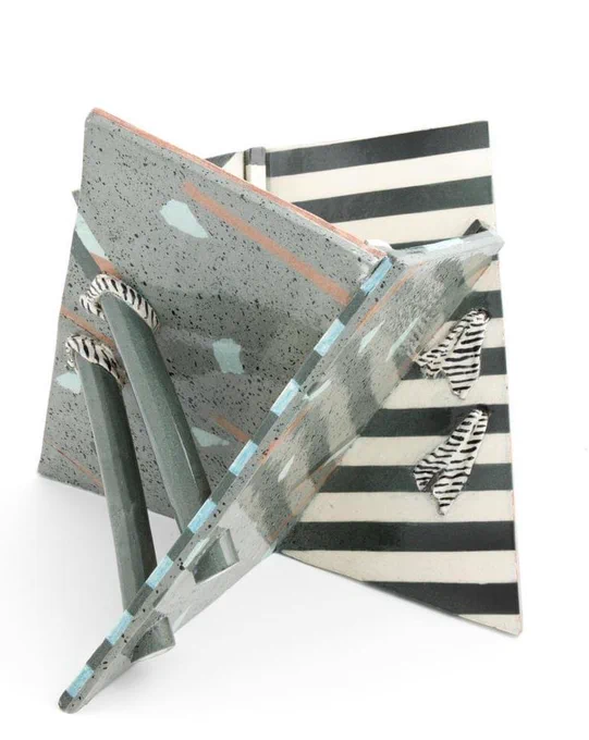 Ceramic vessel composed of three flat upright planes joined together. Each sheet is patterned and glazed in various colours including green, blue, orange, black and cream.