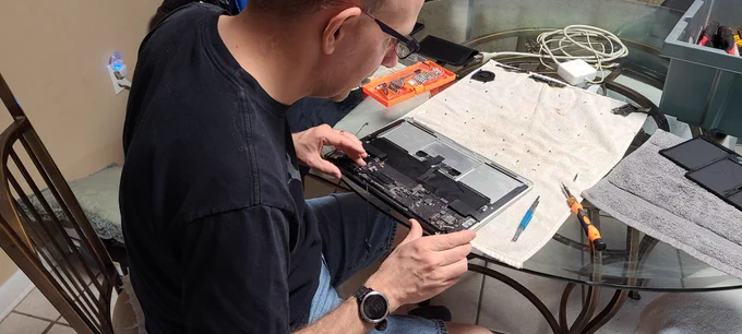 Tech working on innards of a MacBook Air