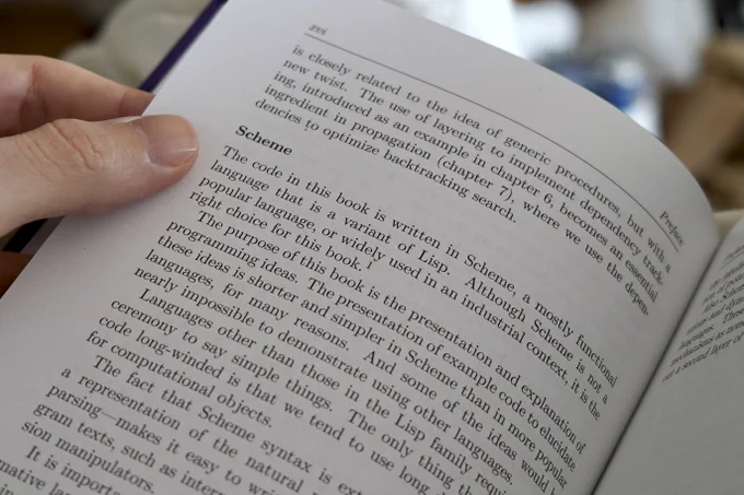 A photo of a page from "Software Design for Flexibility". The focus is on the following paragraph from the preface:

"The code in this book is written in Scheme, a mostly functional language that is a variant of Lisp. Although Scheme is not a popular language, or widely used in an industrial context, it is the right choice for this book."