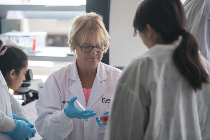 Joanne Free, a lab technologist, shows students some specimens on petri dishes. 