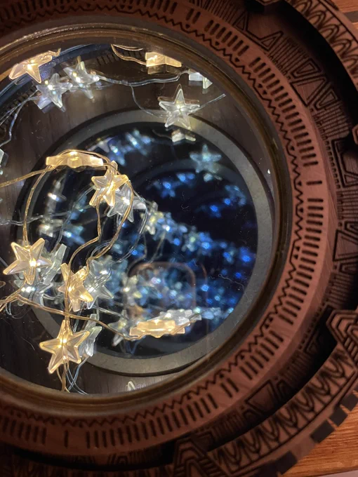 Engraved wood ring with Stargate symbols and a blue infinity mirror reflecting stars in the middle
