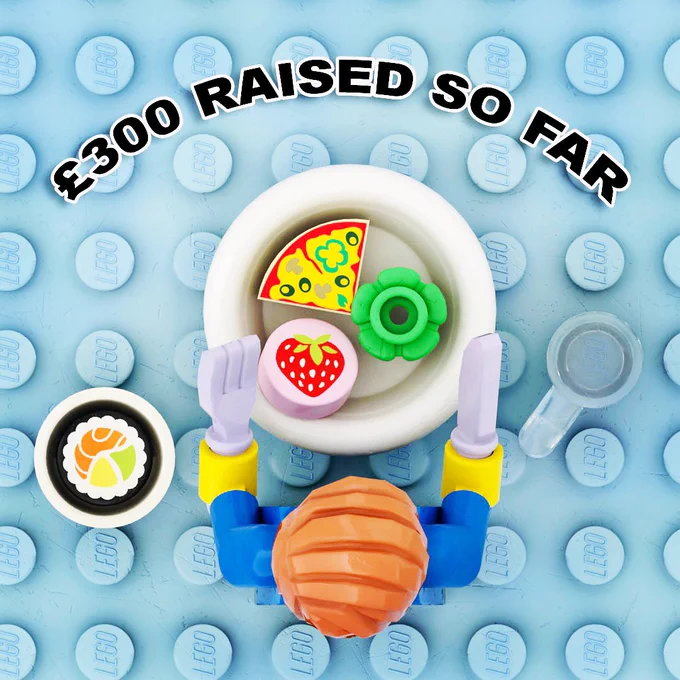 £300 raised so far. Overhead view of minifigure eating Lego sushi, pizza, salad and strawberry with a knife and fork.