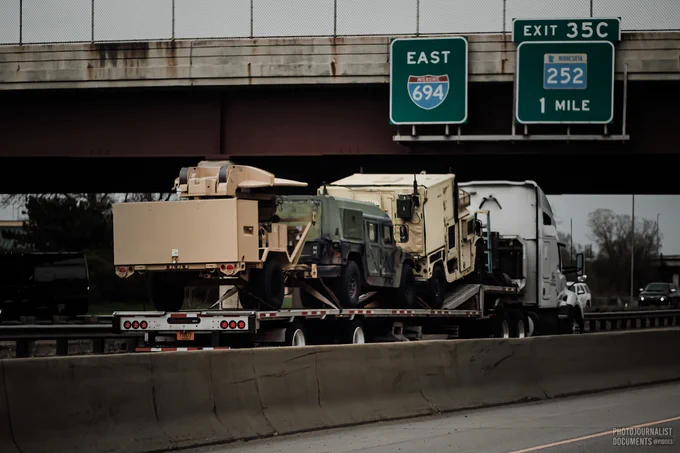 Monday, April 19th, 2021: A flatbed tractor trailer traveling east on 694 carries military vehicles towards Brooklyn Center, Minnesota. Photo by independent frontline photojournalist @pjdocs