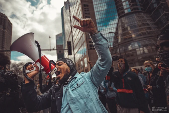 A man celebrates by cheering into his bullhorn, his other hand raised up into the sky (04/20/2021) photo by @pjdocs