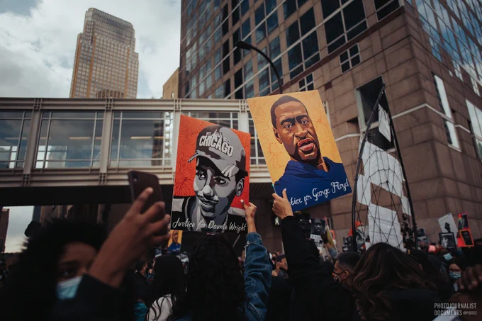 As celebrations, cheers, and chants fill the city, demonstrators hold up signs of two Minnesota men killed by Police. Daunte Wright with a red background on the left, George Floyd with a yellow background on the right. (04/20/2021) photo by @pjdocs