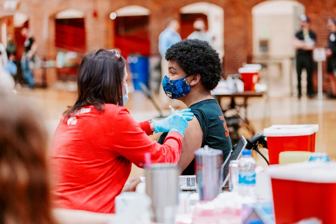 A student receives their first COVID-19 vaccine