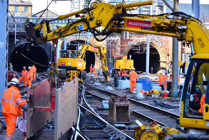 Various pieces of large machinery and workers work on the railway tracks outside London King’s Cross station.
