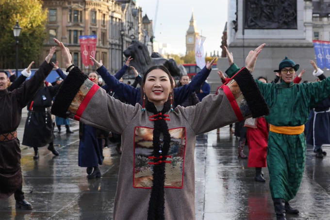 The Mongol Khan company raise arms in air with Big Ben in the background