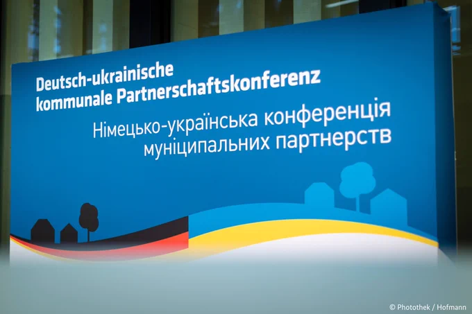 Stand with the logo of the German-Ukrainian municipal partnership conference.