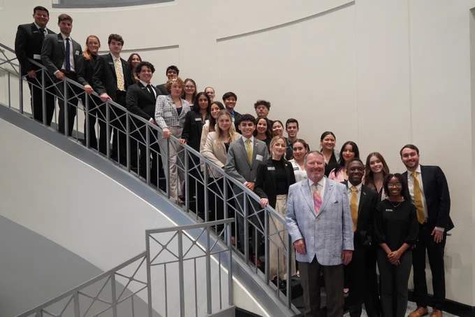 Mayor Dyer stands with UCF Student Government Association students. They are lining stairs in City Hall. 