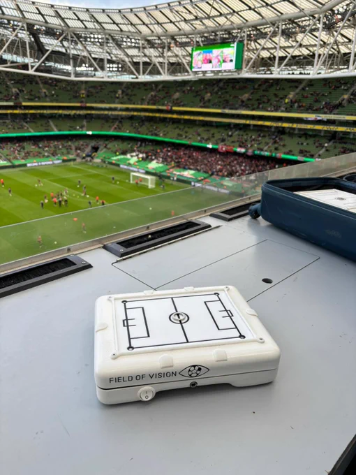 The Field of Vision device in the press box. Bohs fans start to gather in the South stand before the game as Bohs players warm up on the pitch.