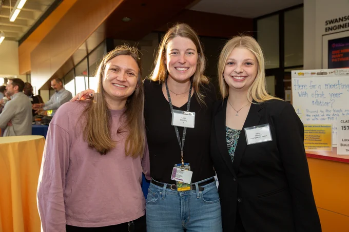 Three young women (two graduate students, one undergrad) stand together for a photo at the BioE Department's 25th anniversary celebration. 