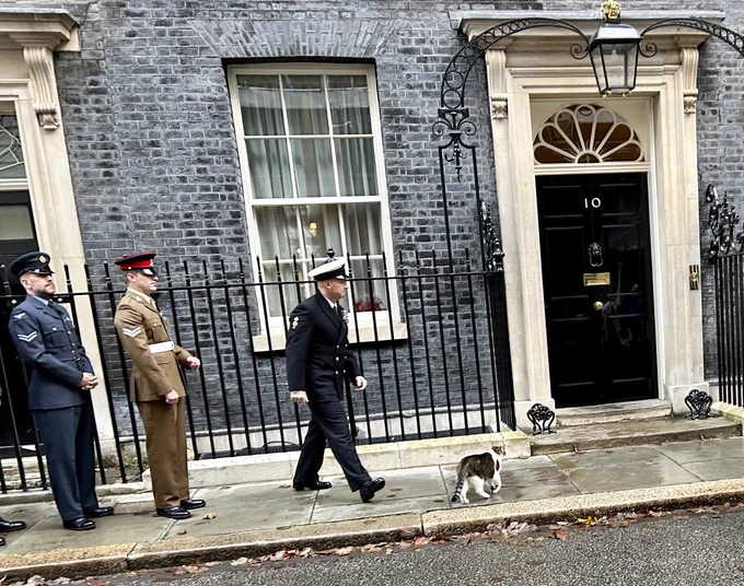 Larry walking with members of the armed services on Downing street