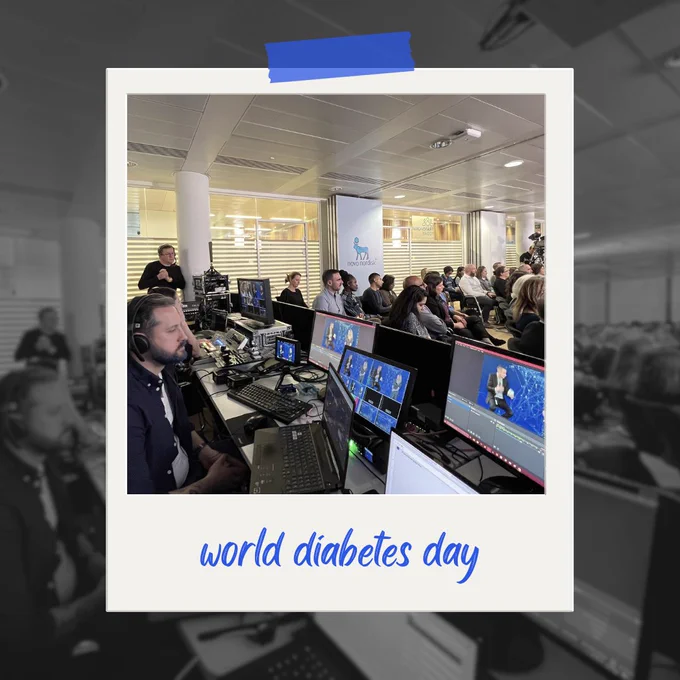 Control room view of a live streaming event with multiple monitors displaying different camera angles. In the foreground, a production team member focuses on a screen, while an audience watches the presentation in the background. The words 'world diabetes day' are captioned at the bottom, and the Novo Nordisk logo is visible in the room.