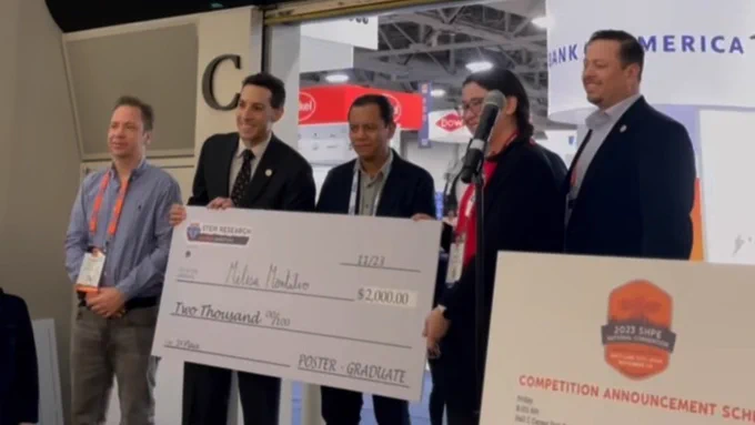 UH ChBE PhD candidate Melisa Montalvo (second from right) stands with four men and receives a large check as her prize for the first-place poster award at the 2023 SHPE National Convention.