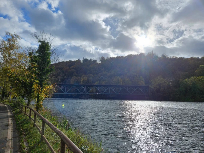 A river, a railway bridge in the distance, all lit by a low autumn sun