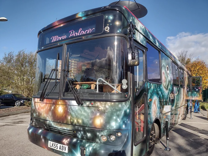 A bus with a spacescape painted on the side