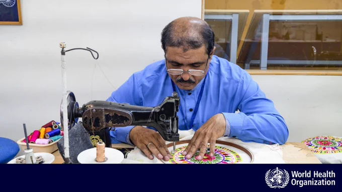 A person with glasses using a sewing machine.