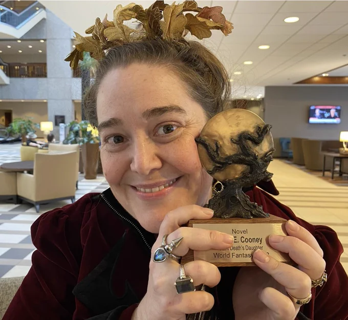 A photo of C. S. E. Cooney smiling and holding her World Fantasy Award for best novel. Taken by Carlos Hernandez.