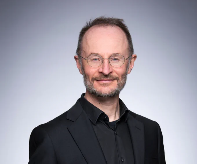 Richard Barwell wearing glasses and smiling at the camera.