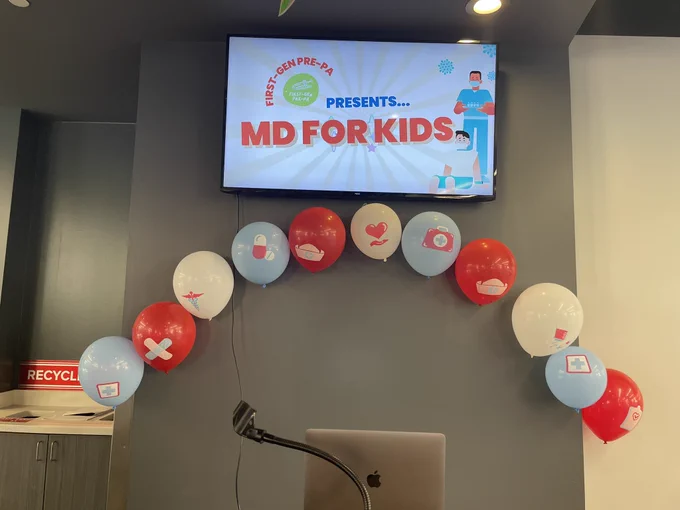 MD for Kids sign with balloon arch and a podium.