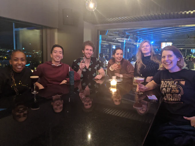 Nice photo of us smiling at the camera and holding up drinks at a restaurant table: Selam, JP, me, Laura, Miriam, and Katy.