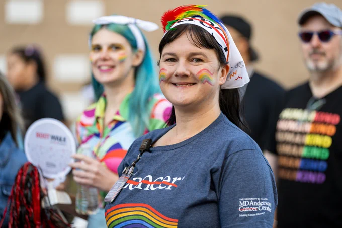 A person wearing a cancer strikethrough headband smiling